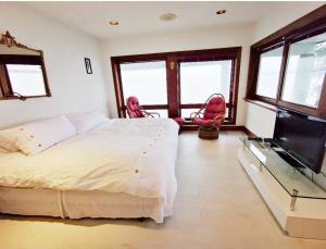1 dormitorio con 1 cama y 2 sillas rosas en Vancouver Castle Waterfront with hot tub beach downtown, en Chemainus