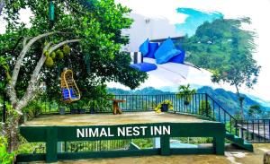 um banco com uma placa que lê ninho pousada inicial em Ella Nimal Nest Inn em Ella