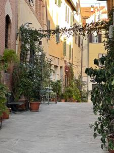 an empty courtyard with plants and tables and buildings at CASA LUCIO in Grosseto