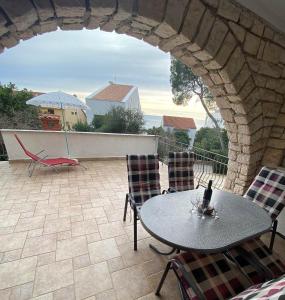 eine Terrasse mit einem Tisch und Stühlen auf dem Balkon in der Unterkunft Balcony apartment on the beach in Rovinj