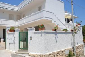 a white house with a white fence and stairs at A casa di Elena in Leuca