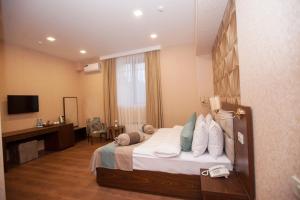 ein Hotelzimmer mit einem Bett und einem Schreibtisch in der Unterkunft Auroom Hotel in Baku