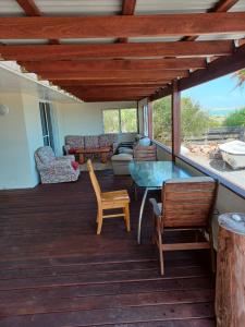 a living room with a wooden deck with a table and chairs at Mermaid Beachside Accommodation in Denham