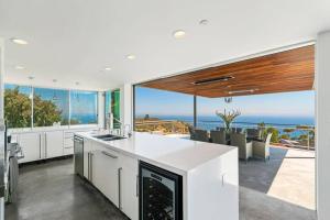a kitchen with a view of the ocean at Malibu Glass House: Architectural w 180deg Views in Malibu