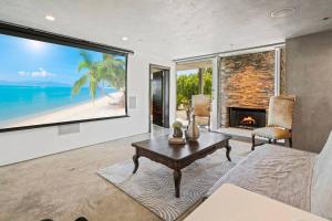 a living room with a fireplace and a large window at Malibu Glass House: Architectural w 180deg Views in Malibu