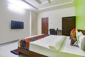 a bedroom with a large bed and a tv at FabHotel Golden Hitech in Hyderabad