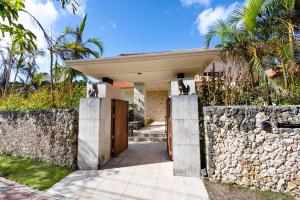 eine Villa mit einer Steinmauer und einem Eingang in der Unterkunft Ocean Front Villa Ishigakijima Ⅰ in Ishigaki-jima