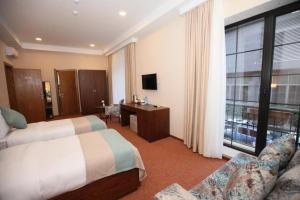 um quarto de hotel com duas camas e uma janela em Auroom Hotel em Baku