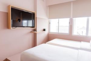 a bedroom with a bed and a flat screen tv at Kotta Hotel Semarang in Semarang