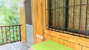 eine abgeschirmte Veranda mit einer Bank und einem Fenster in der Unterkunft Woodland Inn in El Nido