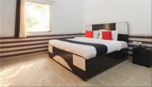 1 dormitorio con 1 cama grande con almohadas rojas en Hotel J.S. Plaza By WB Inn, en Agra