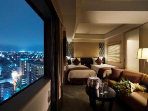 a hotel room with two beds and a large window at ANA Crowne Plaza Kanazawa, an IHG Hotel in Kanazawa