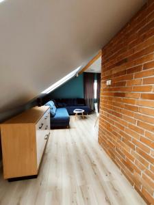 a living room with a couch and a brick wall at Apartament Nad Góralem in Milówka