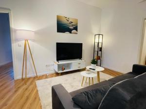 uma sala de estar com um sofá e uma televisão de ecrã plano em schönes Apartment - Netflix-Nespresso em Duisburg