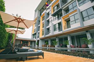 an external view of a hotel with an umbrella at The Zense Boutique Hotel in Phitsanulok