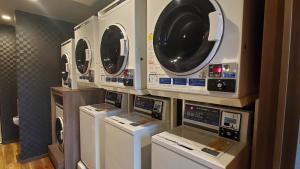 a group of washers and dryers in a laundry room at Hotel Route-Inn Court Nirasaki in Nirasaki