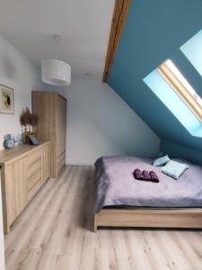 a bedroom with a bed and a blue ceiling at Apartament Nad Góralem in Milówka