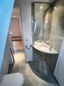 a bathroom with two sinks and a toilet at LOFT-Panoramablick-HAFEN & ELBE! in Hamburg