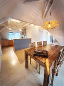 ein Esszimmer mit einem Holztisch und einer Küche in der Unterkunft LOFT-Panoramablick-HAFEN & ELBE! in Hamburg