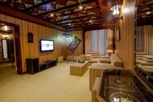a living room with a couch and a tv at HAFFA HOUSE HOTEL in Muscat