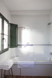 a white bathroom with a tub and a sink at Hotel Tugasa Sierra y Cal in Olvera