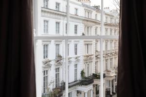 een raam met uitzicht op een groot wit gebouw bij Bob W Hyde Park in Londen