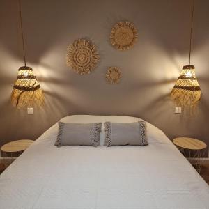 - une chambre avec 2 oreillers sur un lit avec 2 lumières dans l'établissement LES PORTSALLAISES piscine ou spa à 300m de la plage, à Ploudalmézeau