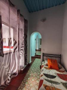a bedroom with a bed in a room with a hallway at Riad Sidi Magdoul in Essaouira