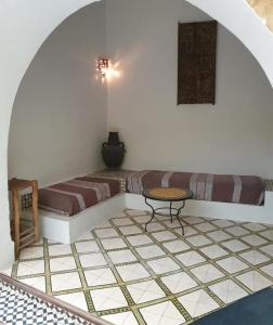 a room with a couch and a table on a tiled floor at Riad Sidi Magdoul in Essaouira