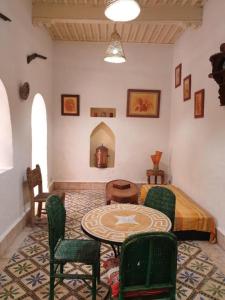 a room with a table and chairs and a bed at Riad Sidi Magdoul in Essaouira