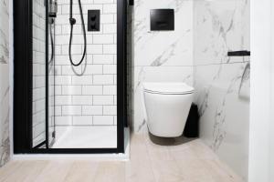 a white bathroom with a shower and a toilet at Bob W Hyde Park in London