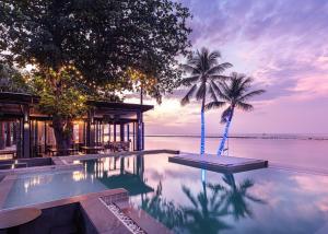 a pool with two palm trees and a house at Lub d Koh Samui Chaweng Beach - Beachfront & Vibrant Social Vibe in Chaweng