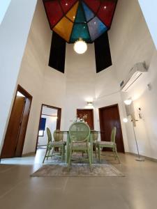 a dining room with a table and chairs and a stained glass ceiling at Peace Farm in Hatta