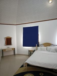 a bedroom with a large bed and a blue screen at Peace Farm in Hatta