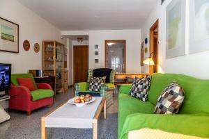 uma sala de estar com sofás verdes e uma televisão em Valencia Flat Rental Patacona Beach em Valência
