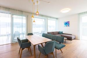 a living room with a table and chairs and a couch at Hermitage Apartments in Maria Wörth