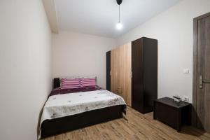 1 dormitorio con 1 cama y armario de madera en Διαμέρισμα κοντά στο μουσείο τρένων, en Drama