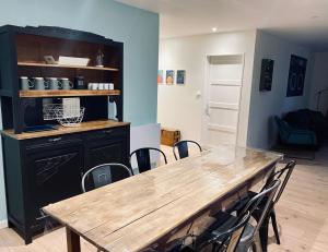 a dining room with a wooden table and chairs at Le Biclou- 3 chambres in Bazincourt-sur-Saulx
