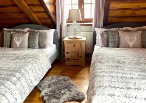 ein Schlafzimmer mit 2 Betten und einem Tisch mit einer Lampe in der Unterkunft Domek na Cuplu - opcjonalnie balia jacuzzi in Szczyrk