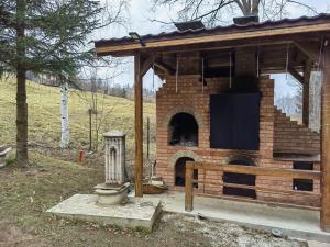 a brick oven in a house with a fence at Cabana Aura Campulung Moldovenesc in Câmpulung Moldovenesc