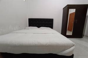 a bedroom with a large bed with a mirror at OYO 92176 Sandira Syariah in Dumai