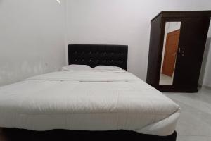 OYO 92176 Sandira Syariah في دماي: غرفة نوم بسرير كبير مع مرآة