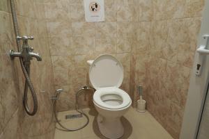 a bathroom with a toilet and a shower at OYO 92176 Sandira Syariah in Dumai