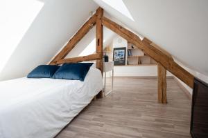 a bedroom with a white bed and wooden beams at Maison Hestiia Vexin 