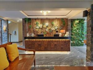 un vestíbulo con un bar con una pared de flores en The Batu Hotel & Villas, en Batu