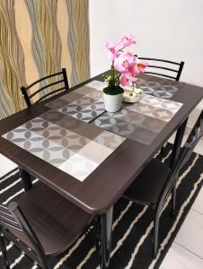 a dining room table with a black and white checkered table at Anggun Homestay in Seri Iskandar