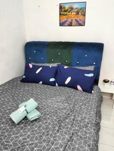 1 dormitorio con 1 cama con 2 almohadas en Anggun Homestay en Seri Iskandar