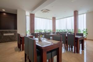 a dining room with tables and chairs and a large window at HOTEL BLUEMOON in Tirunelveli