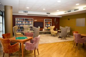 a library with chairs and tables and a tv at Domitys Le Phare d'Argent in Cherbourg en Cotentin