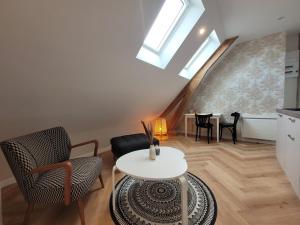 een woonkamer met een witte tafel en stoelen bij Les apparts de Léon in Landerneau